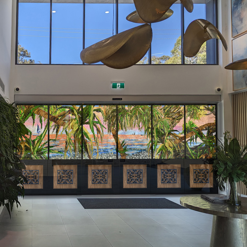 plantation style door disguise on glass doors in a aged care facility with a artwork  giving people a view of the nearby beach